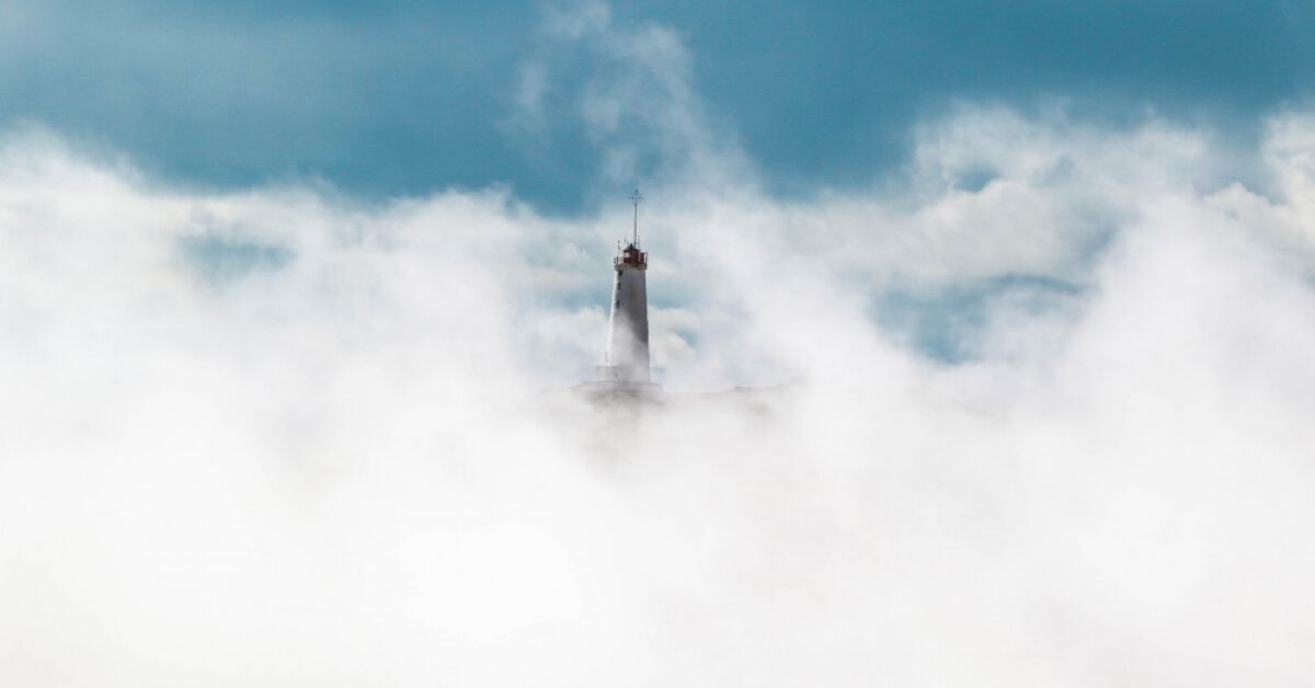 A lighthouse visible amongst fog
