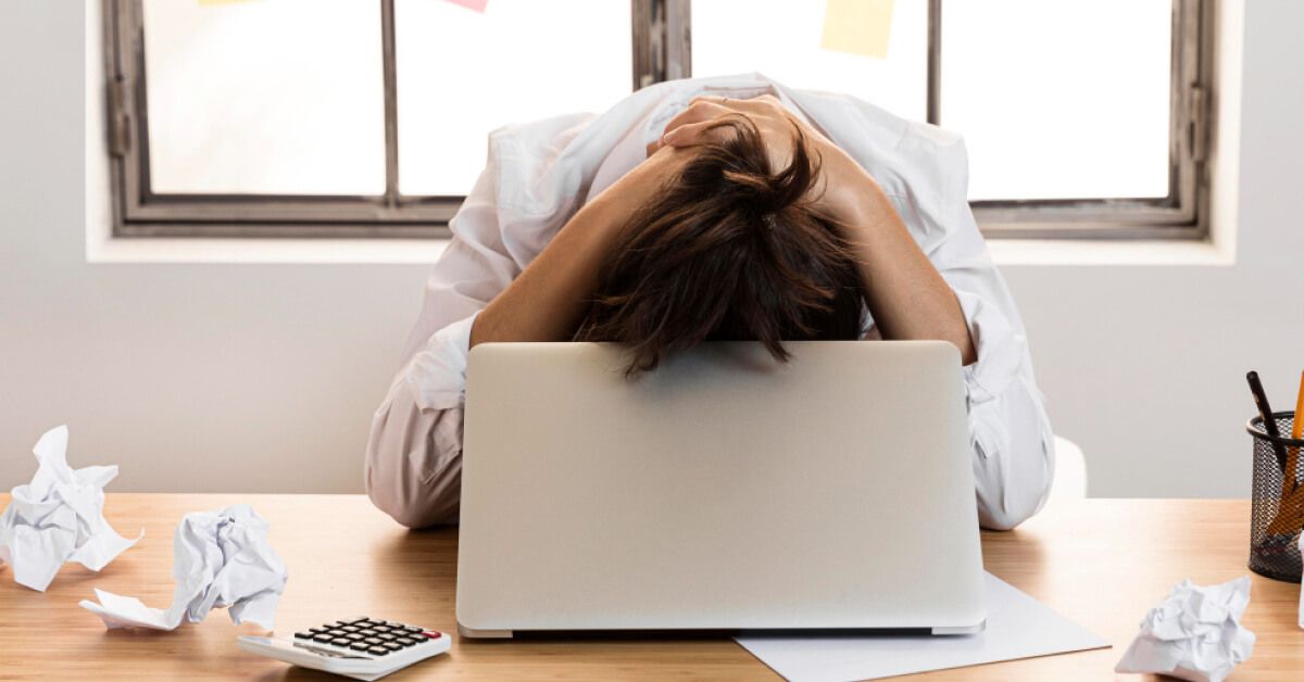 Frustrated person with an open laptop on a work desk