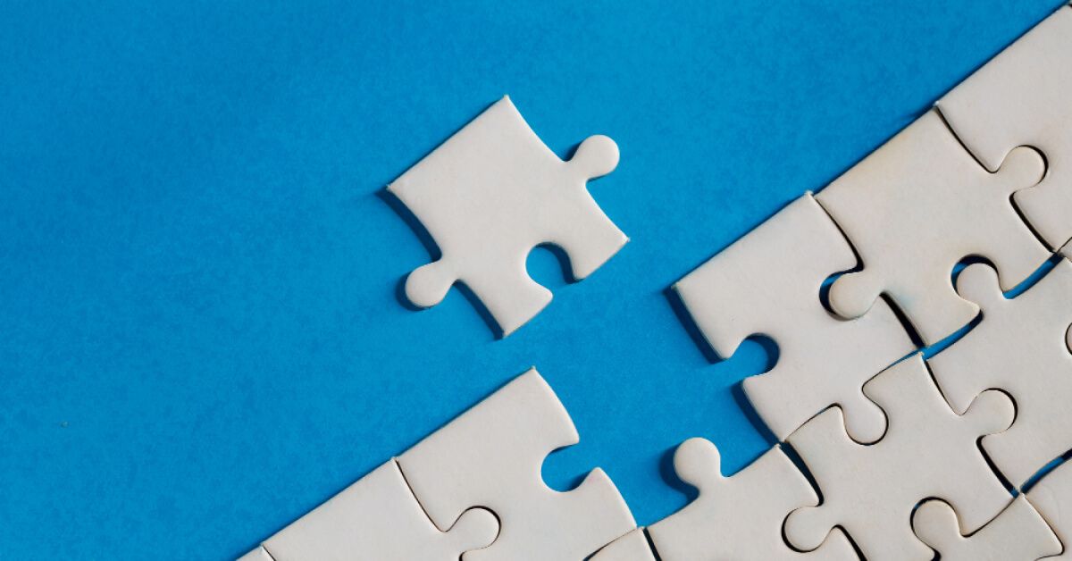 White puzzle pieces laid against a blue backdrop