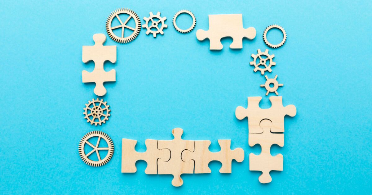 Puzzle pieces and gears against a blue backdrop