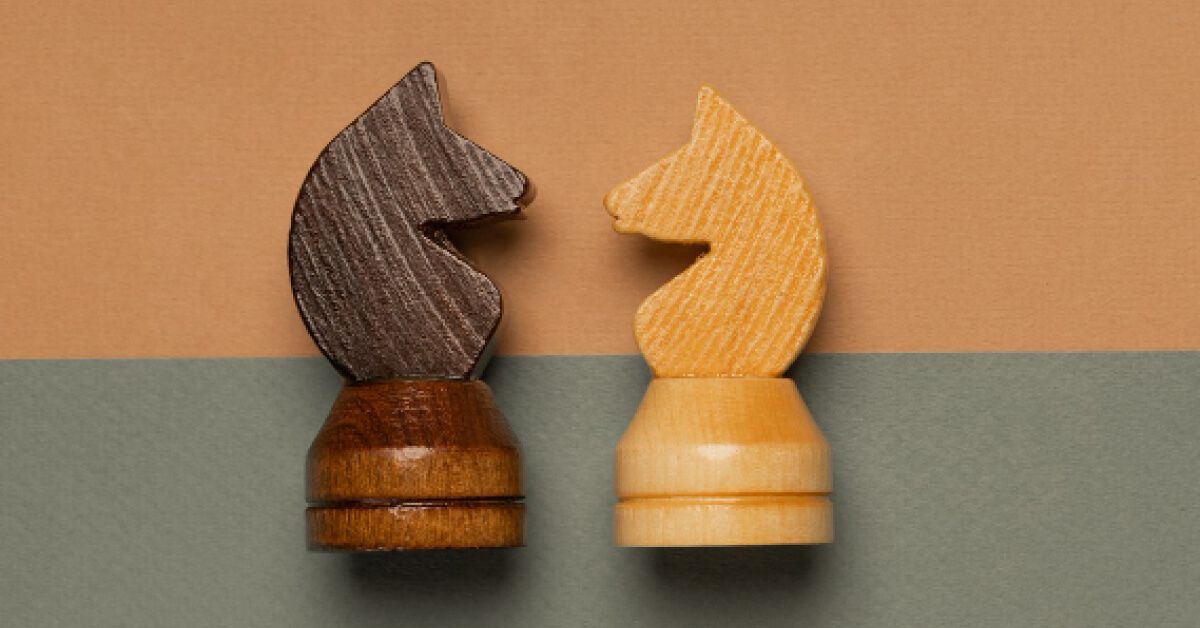 White and black chess knights facing each other