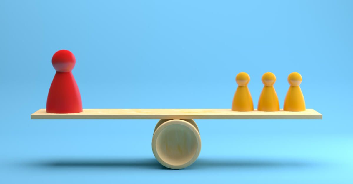 Red and yellow figurines placed on a wooden balancing board