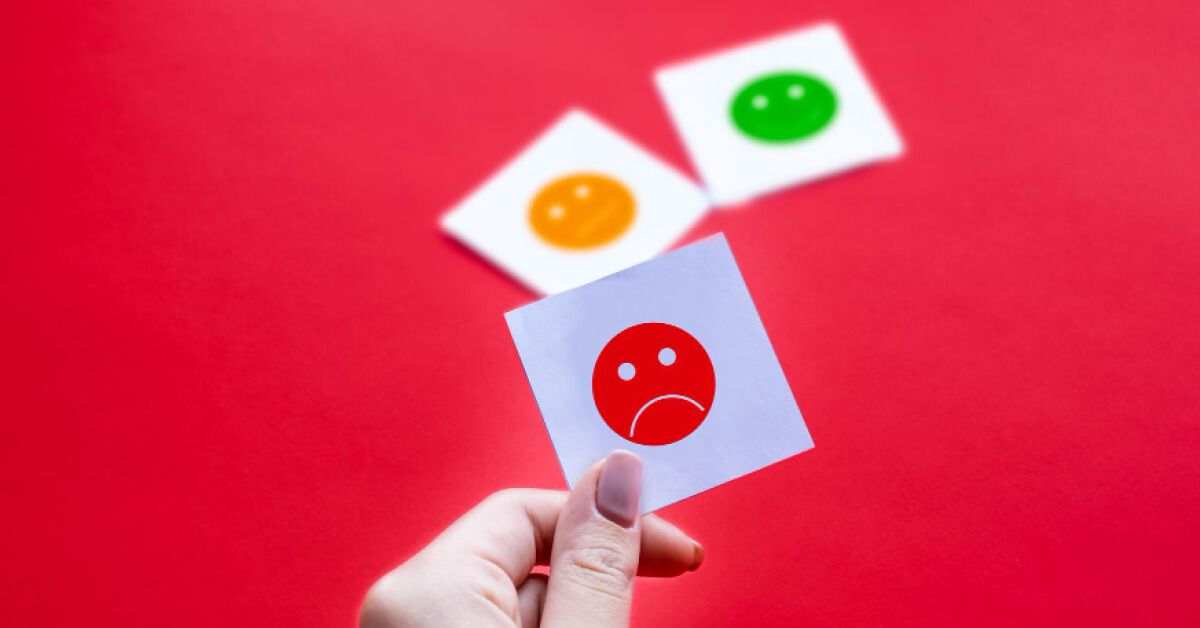 Person holding an emoticon card