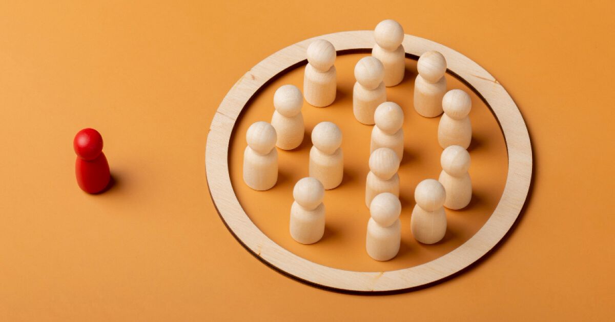 Red pawn standing away from a group of white pawns
