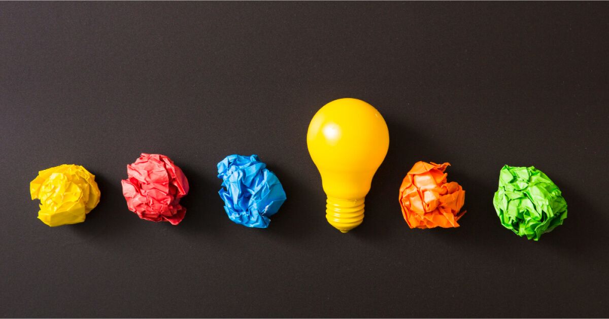 Coloured crushed up paper balls next to a yellow bulb