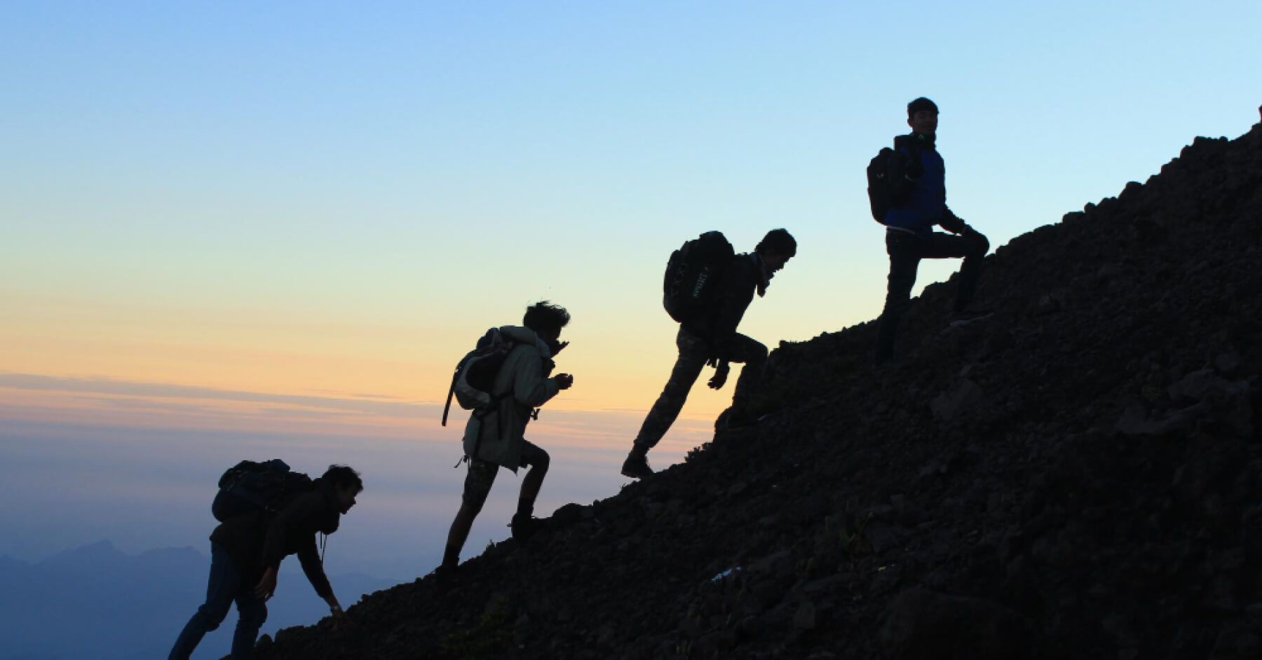 Hikers climbing the top of a mountain