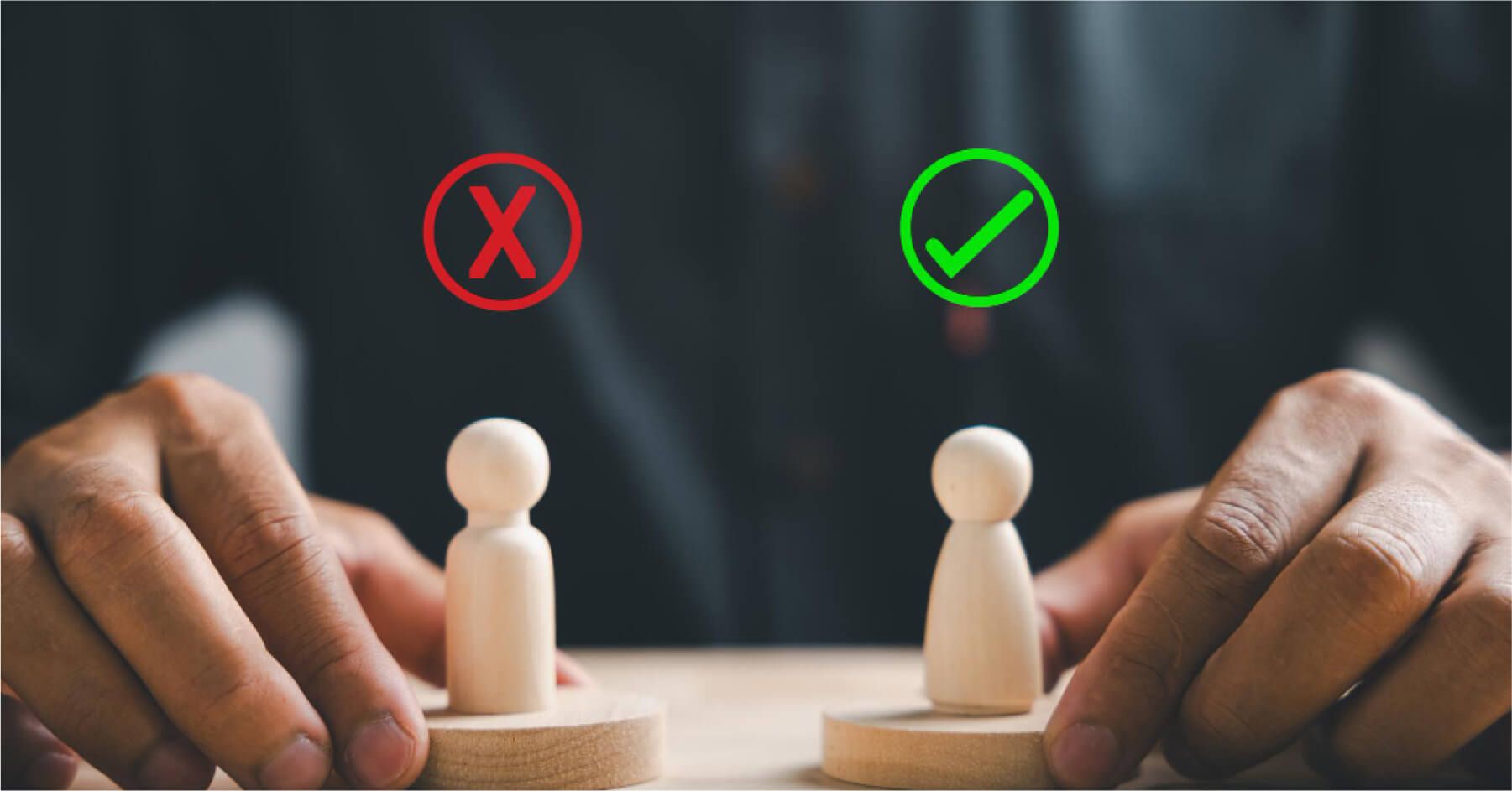 Mans hand holding two wooden choices yes or no peg dolls