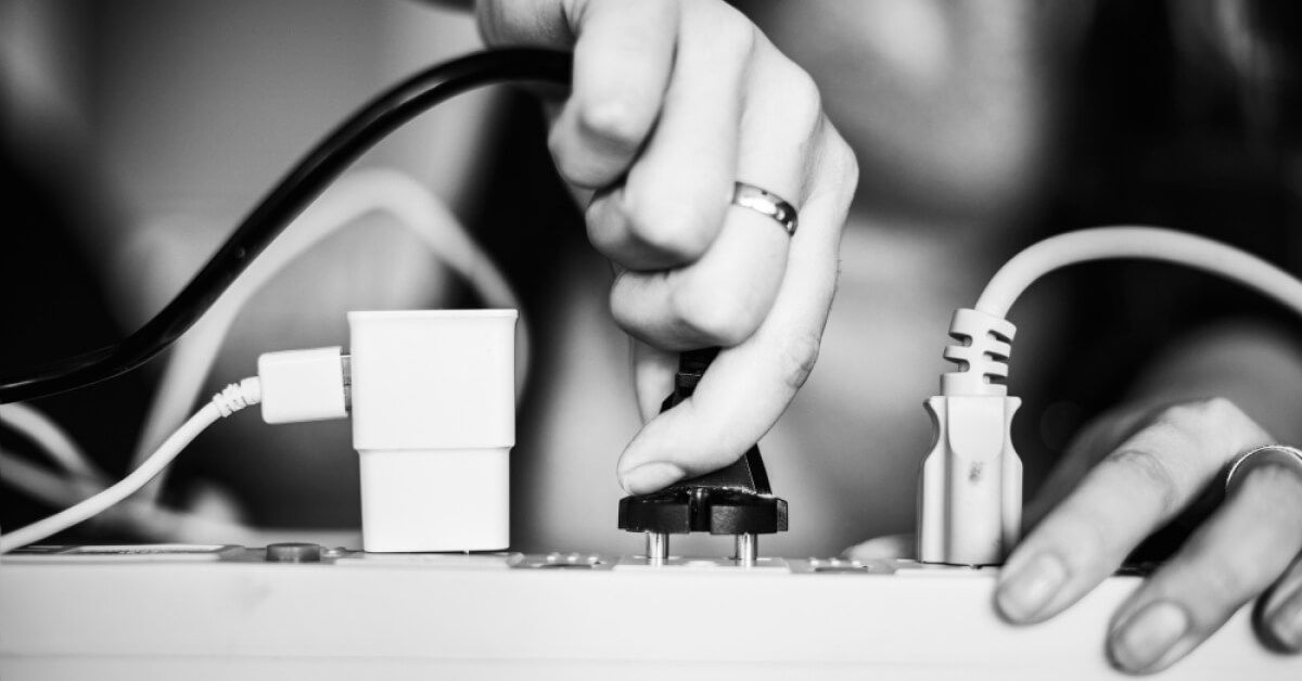 A woman plugging in a device using a power socket