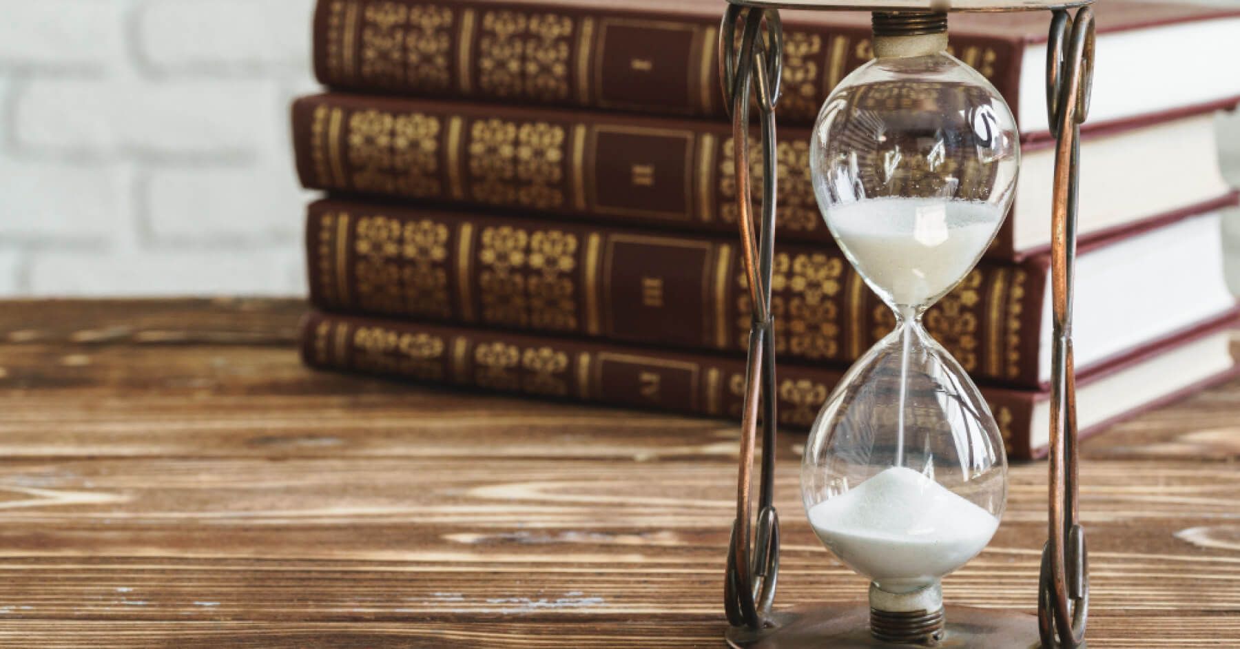 Hourglass against a pretty backgrounds with books
