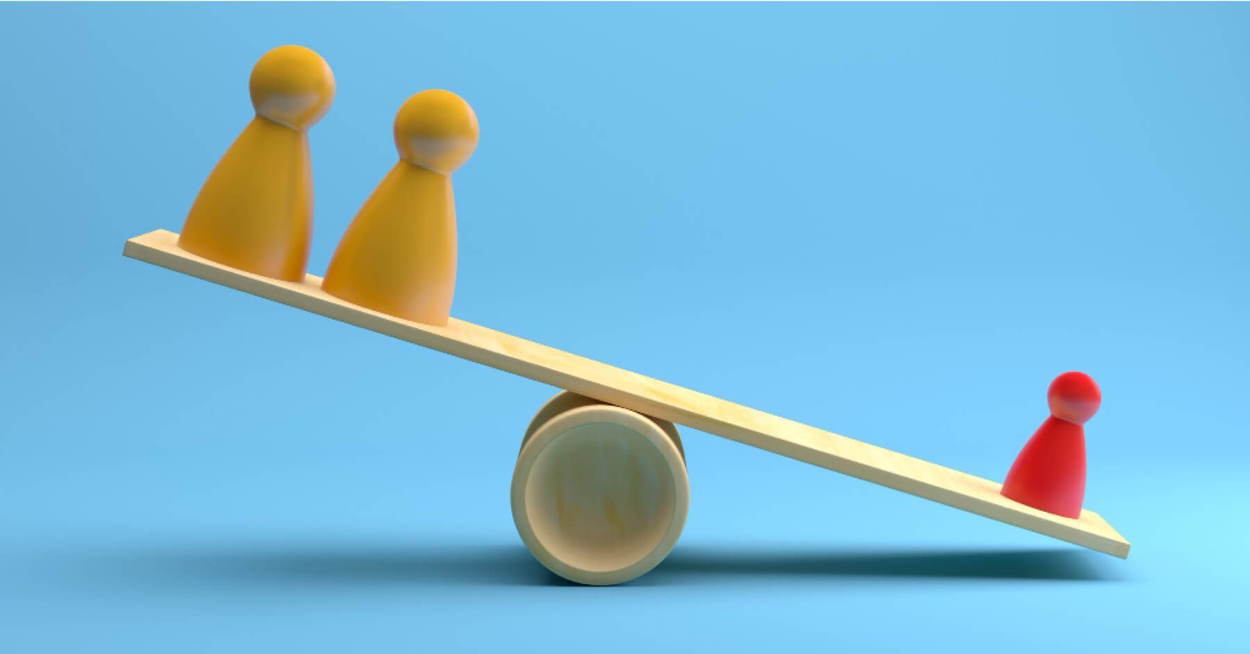 Red and yellow figurines placed on a wooden balancing board
