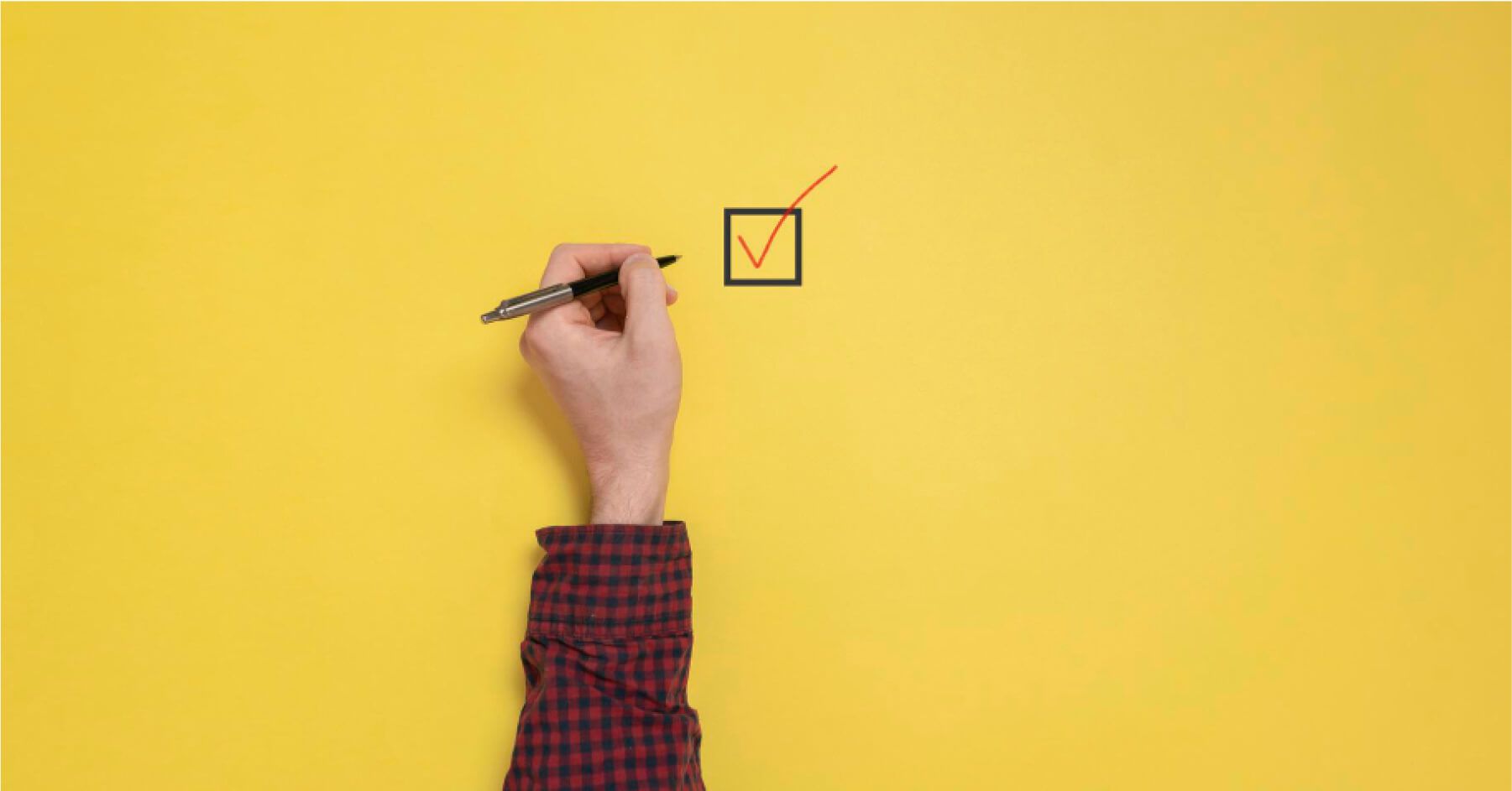 Person with a pen checking a box