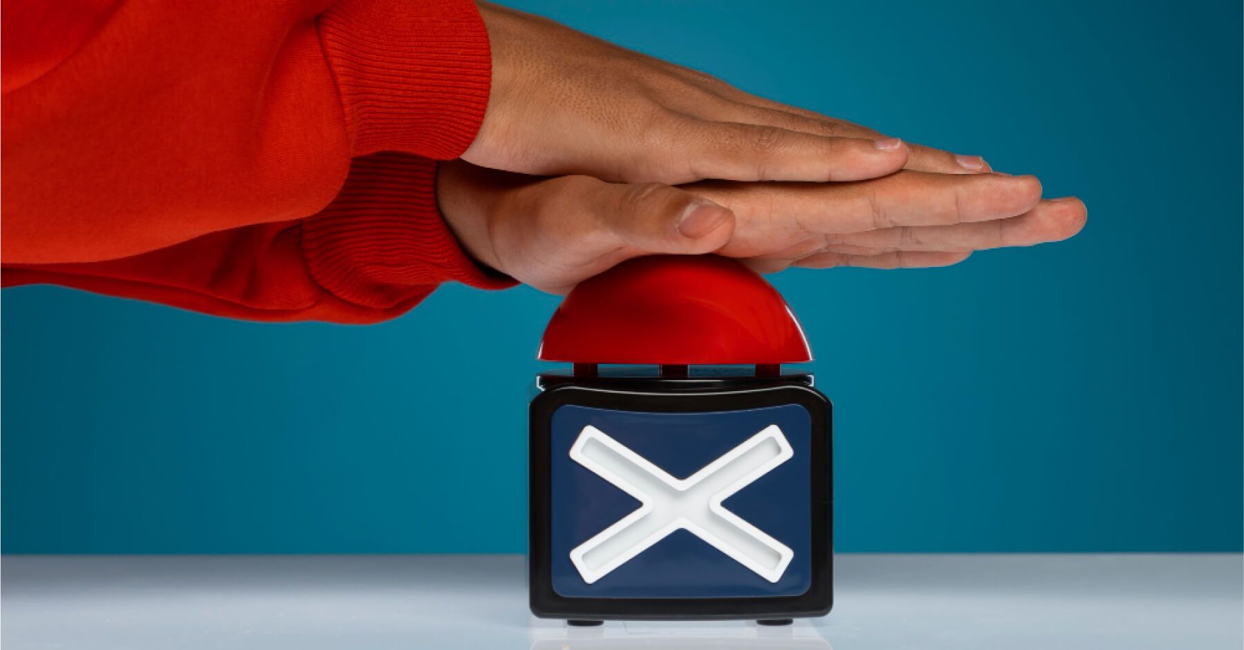 Person pressing a red buzzer
