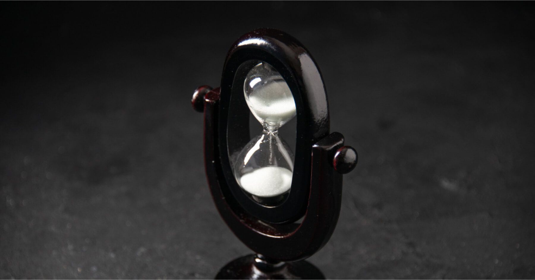 Front view of designed hourglass black colored on dark surface