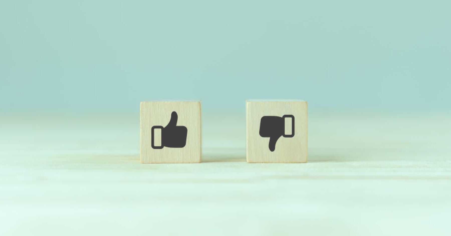 Wooden blocks with thumbs up and thumbs down icons