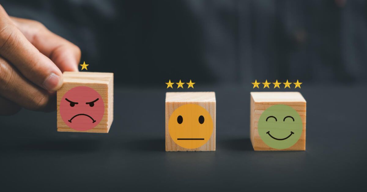 Person placing a wooden block with emoticon and rating into a series