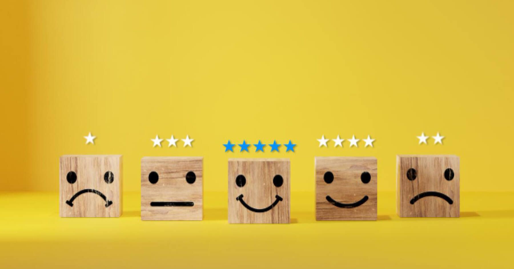 Wooden blocks with emoticon faces and rating scales above them