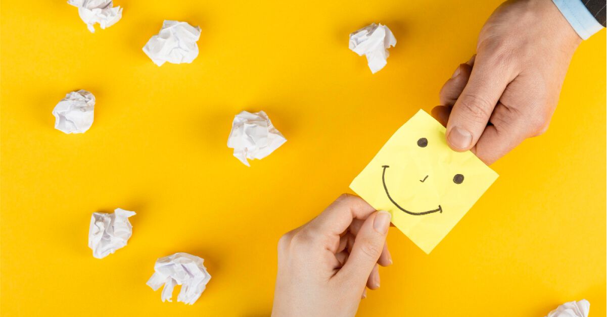 Employee sharing a sticky note with a smiley on it