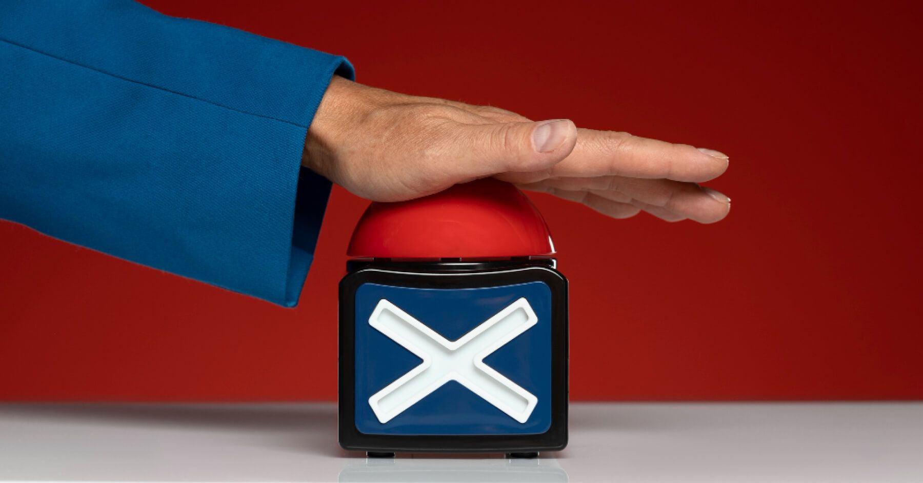 Person pressing a red buzzer