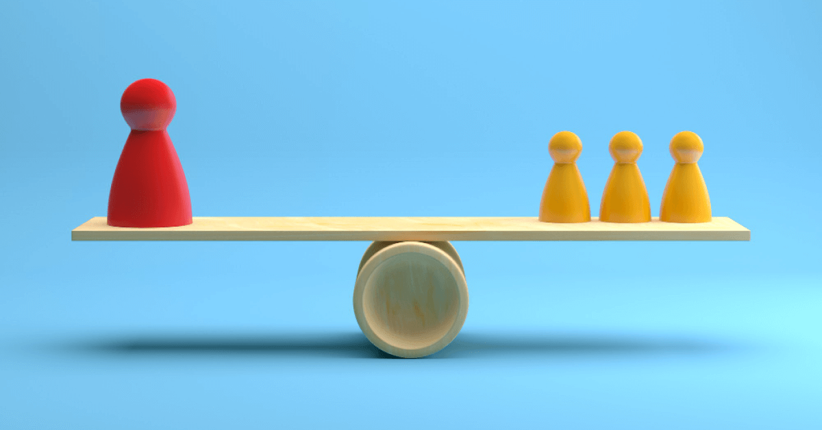 Red and yellow figurines placed on a wooden balancing board
