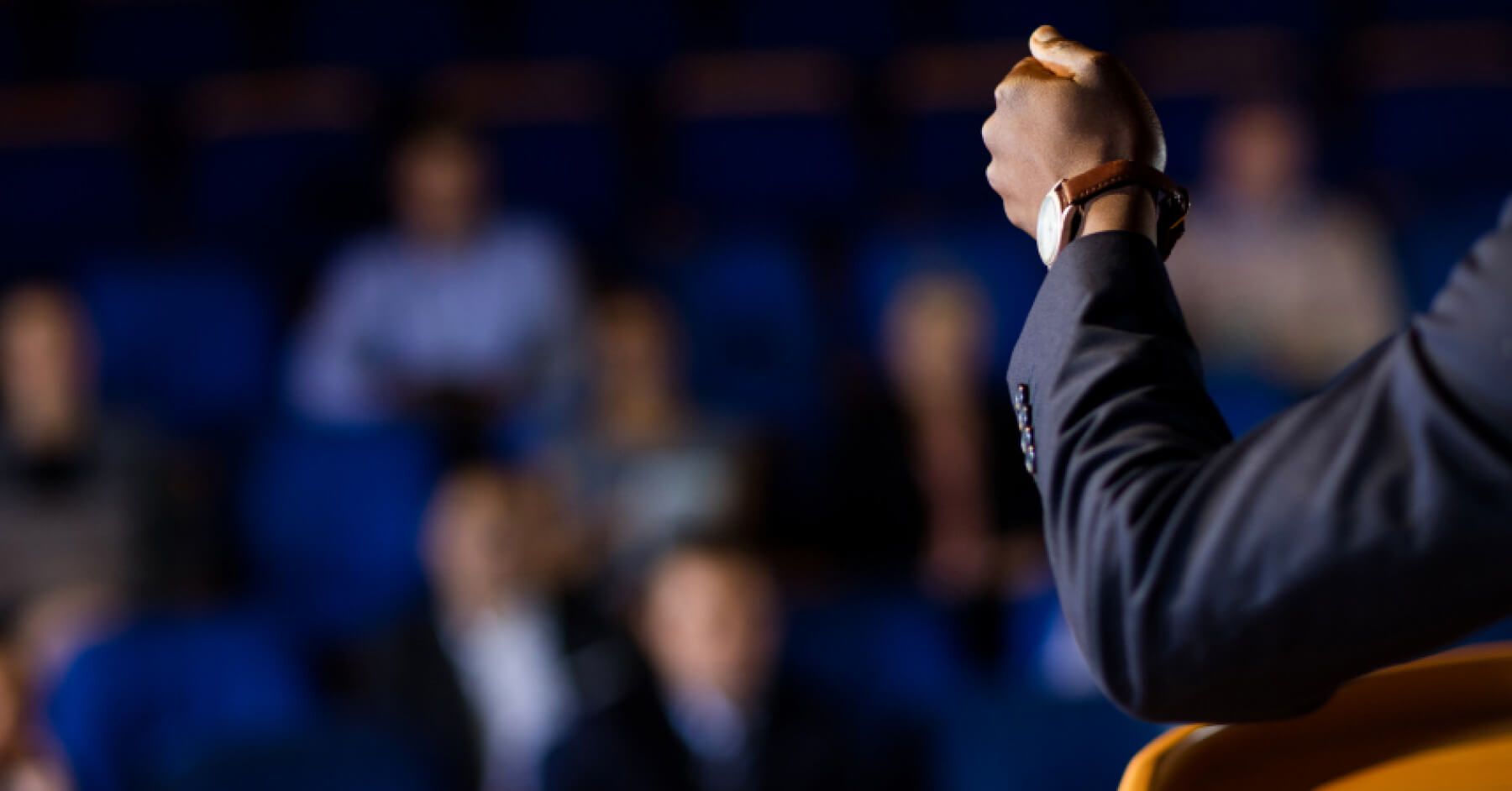 People in a conference hall, paying attention to a speaker