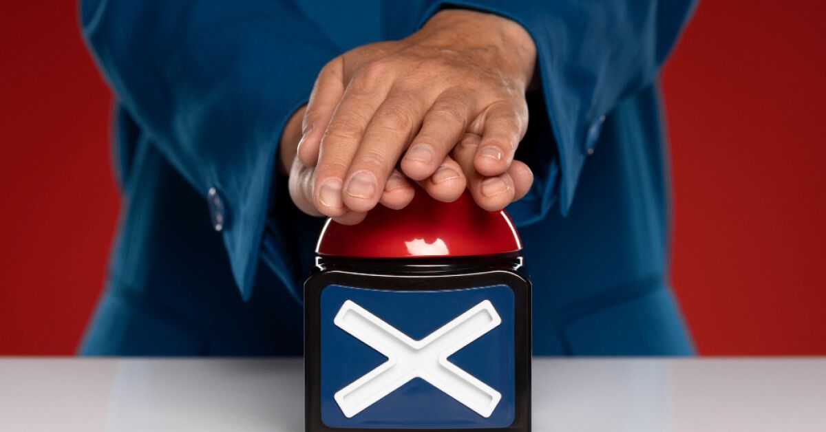 Person pressing a red buzzer
