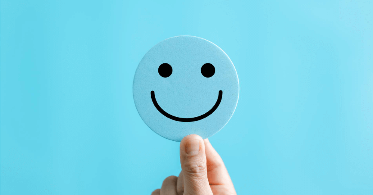 Person holding a blue emoticon card