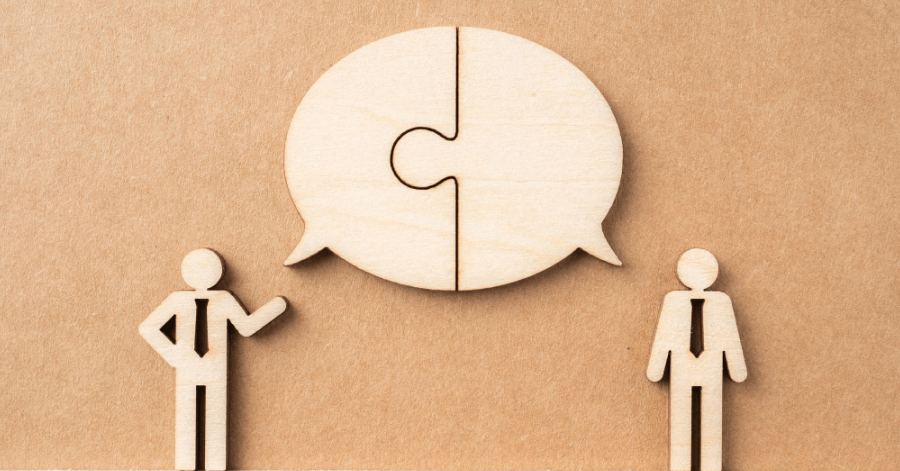 Two wooden shaped cut outs having a conversation