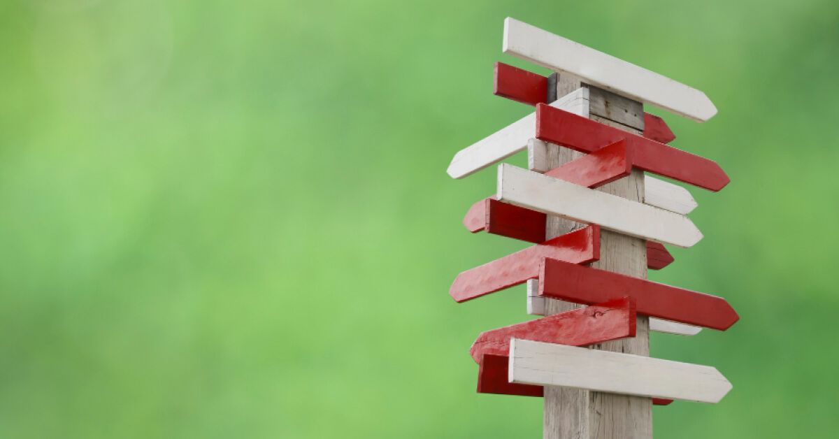 White and red direction boards on a pole