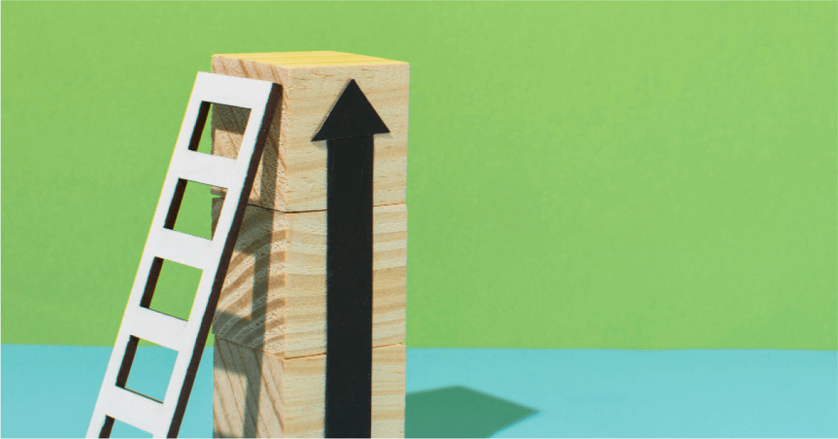 Cardboard ladder leaning on a tower of wooden blocks