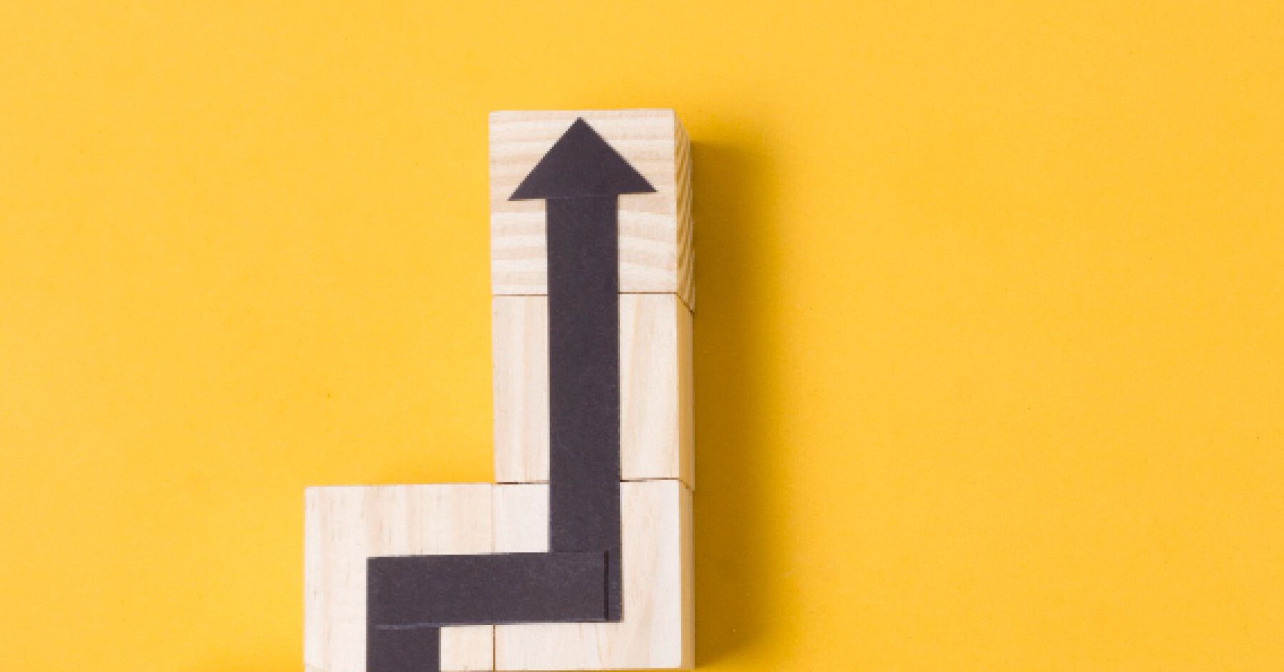 Wooden blocks with a black paper arrow on them