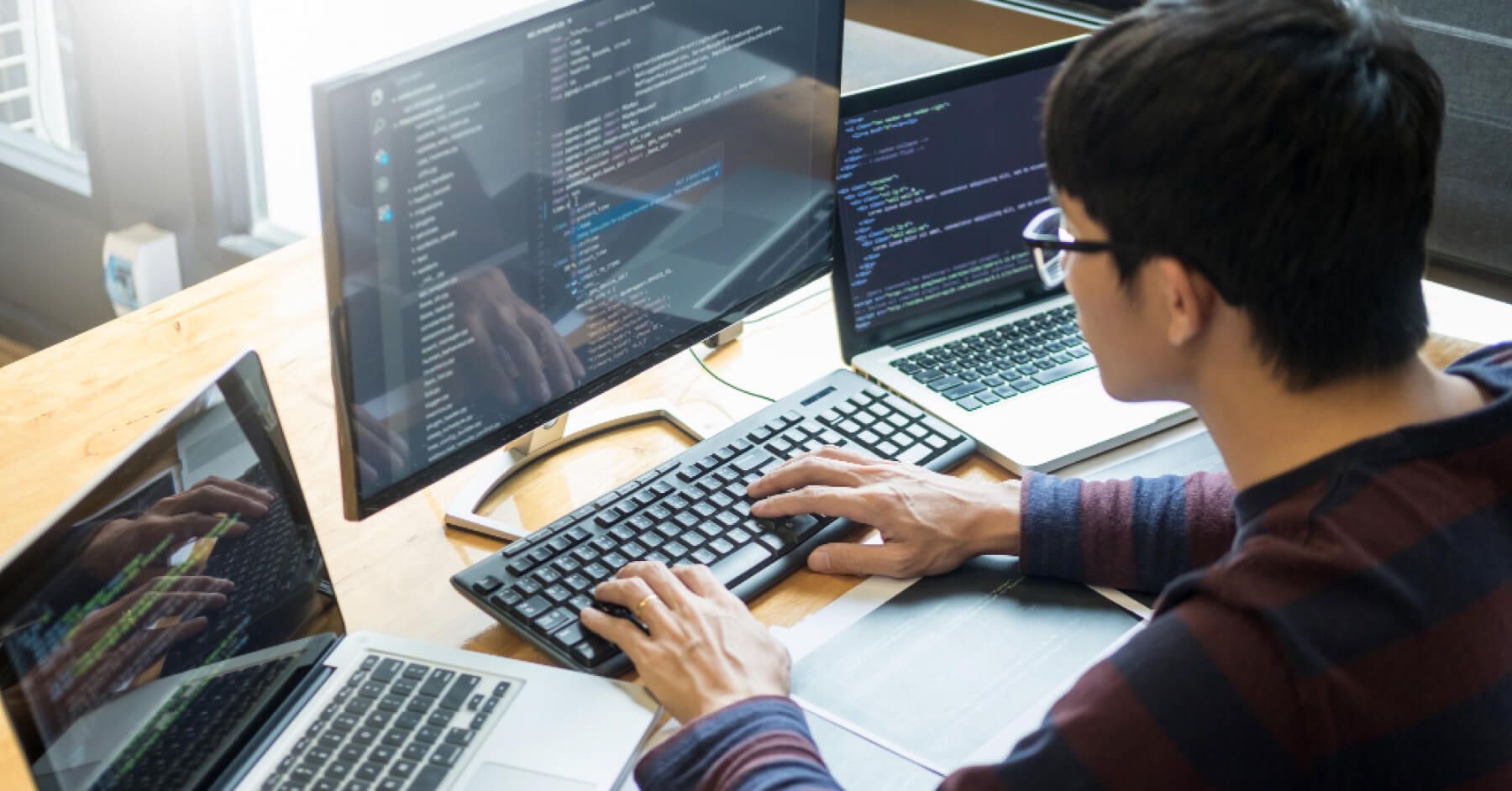 Person using three computers