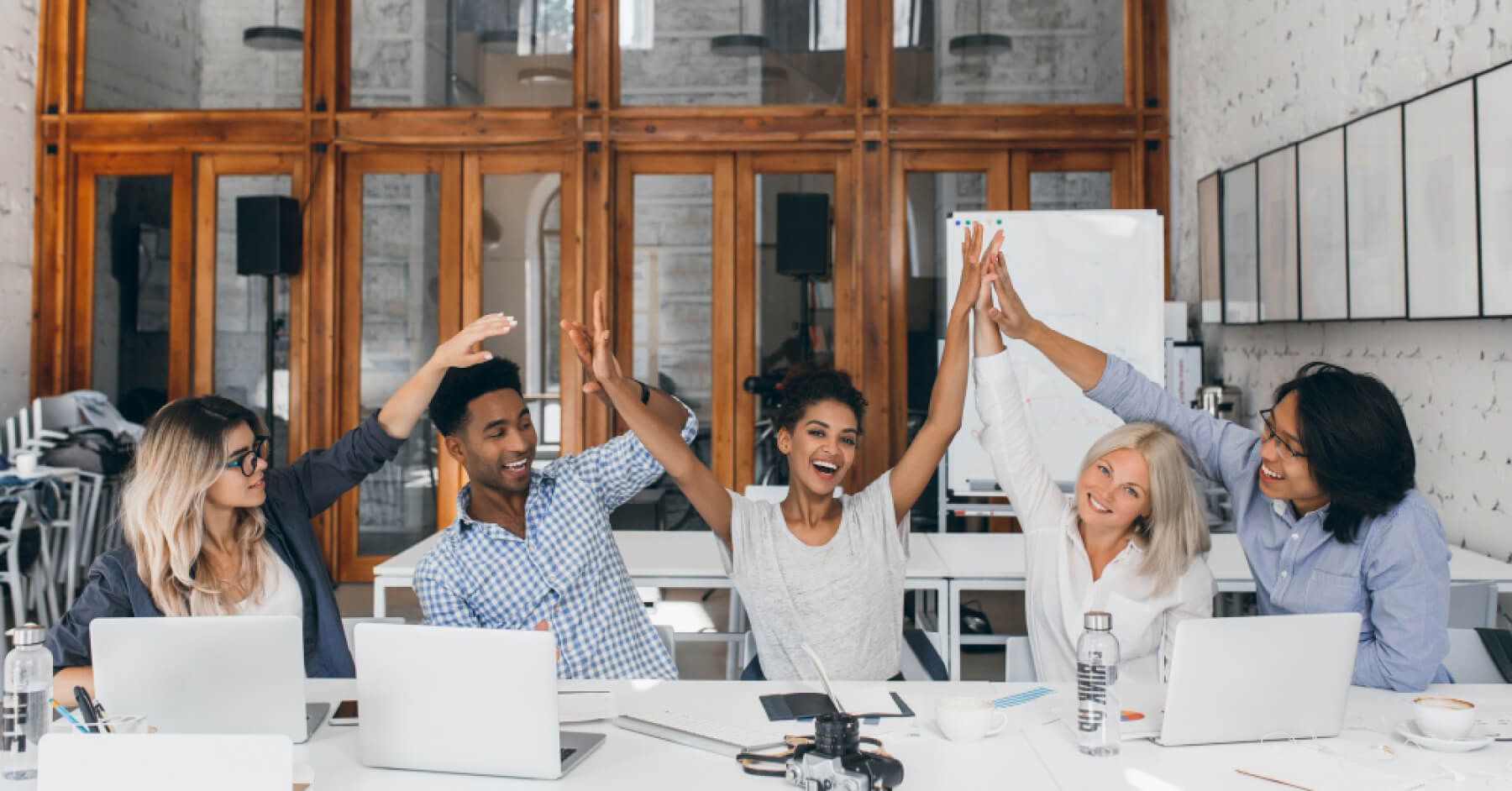 Diverse set of employees participating in a group cheer