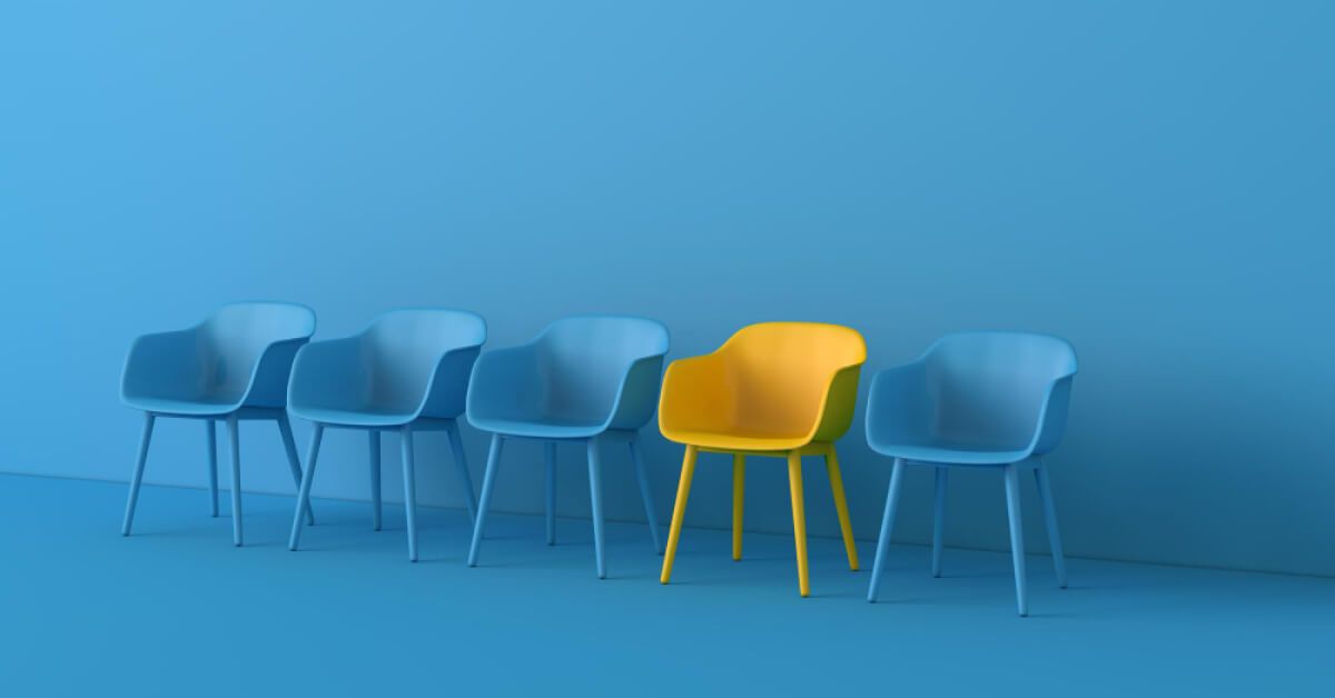 Five chairs with the fourth one being yellow and the rest four being blue