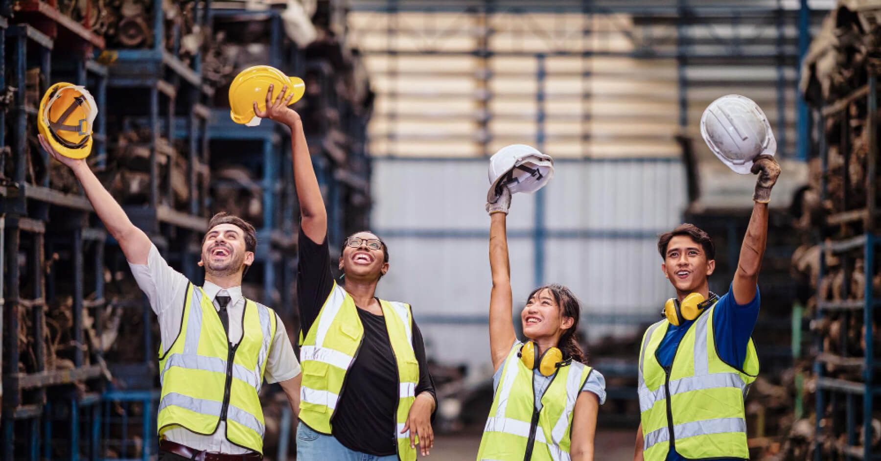 Blue-collar employees happily flexing their helmets