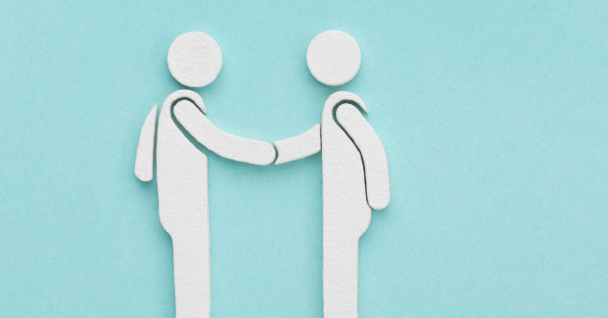 Two paper people shaking each others hands