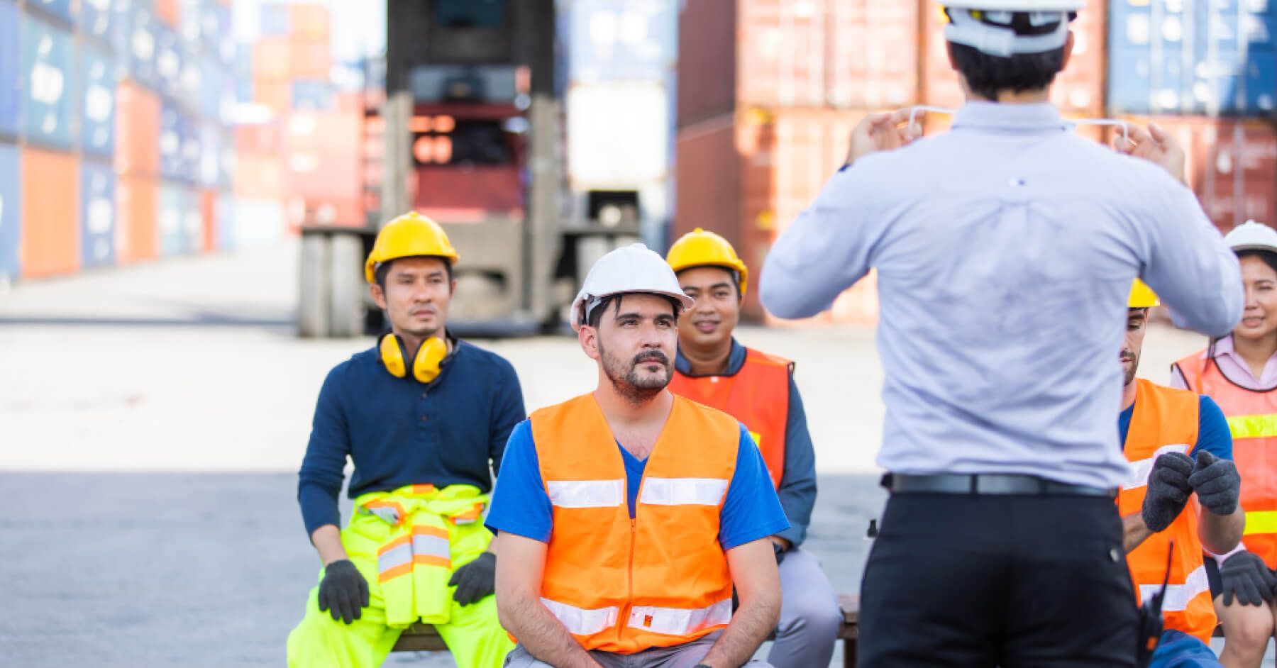 Blue collar workers being instructed by a manager