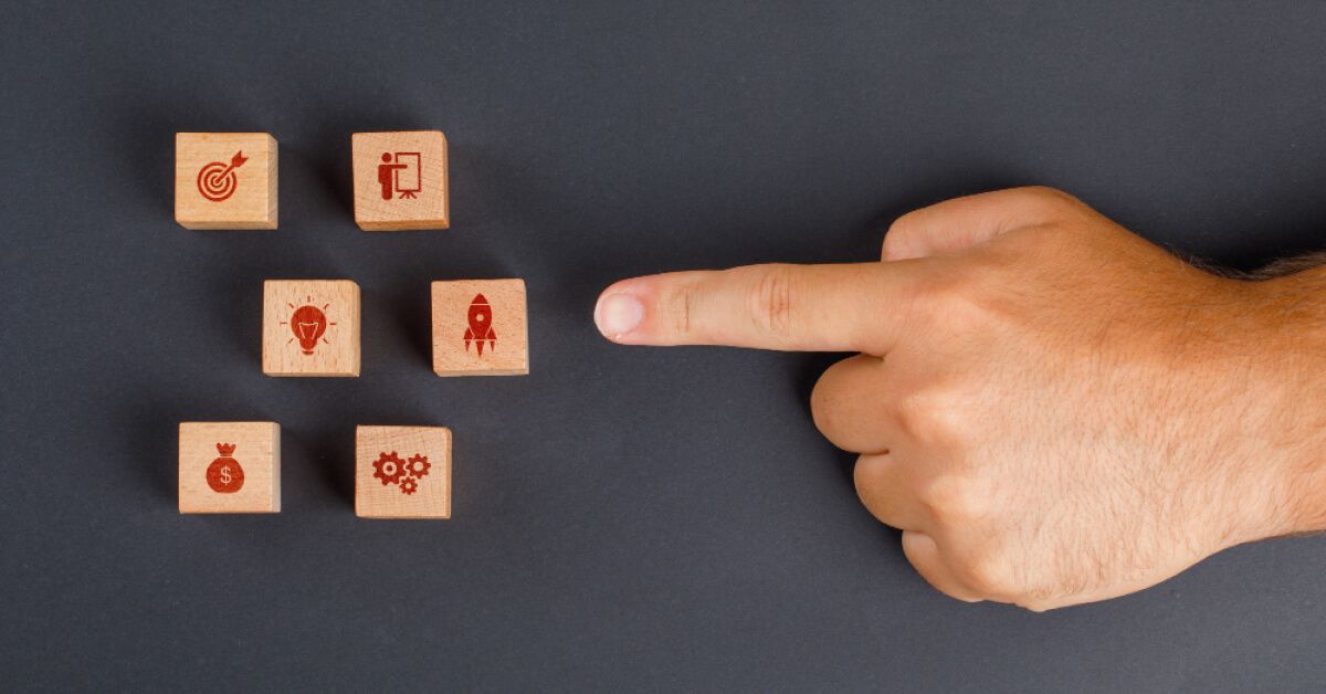 Employee pointing to key areas of satisfaction wooden blocks