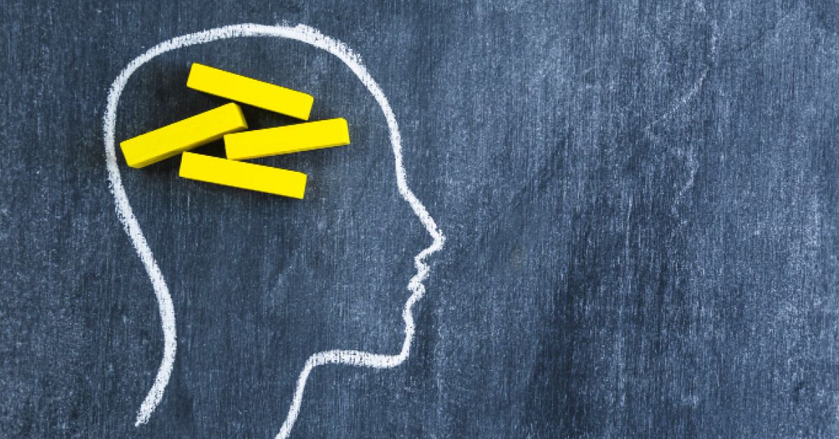 Chalk drawing of a head and yellow chalks as brain inside it