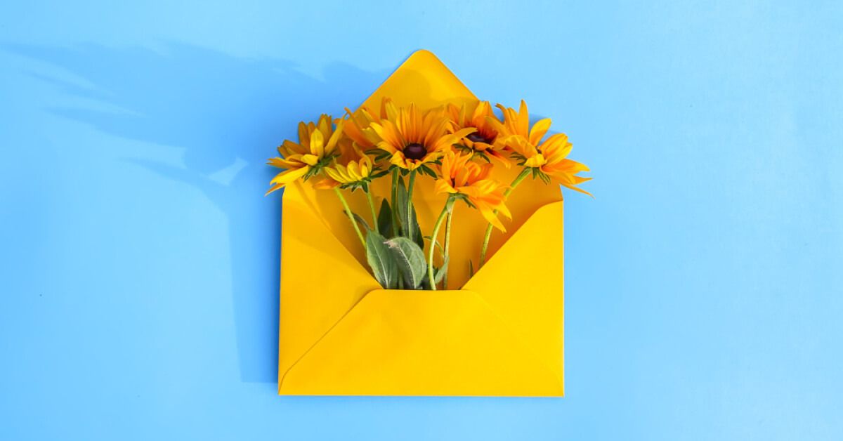 Yellow envelop with yellow daisies in it