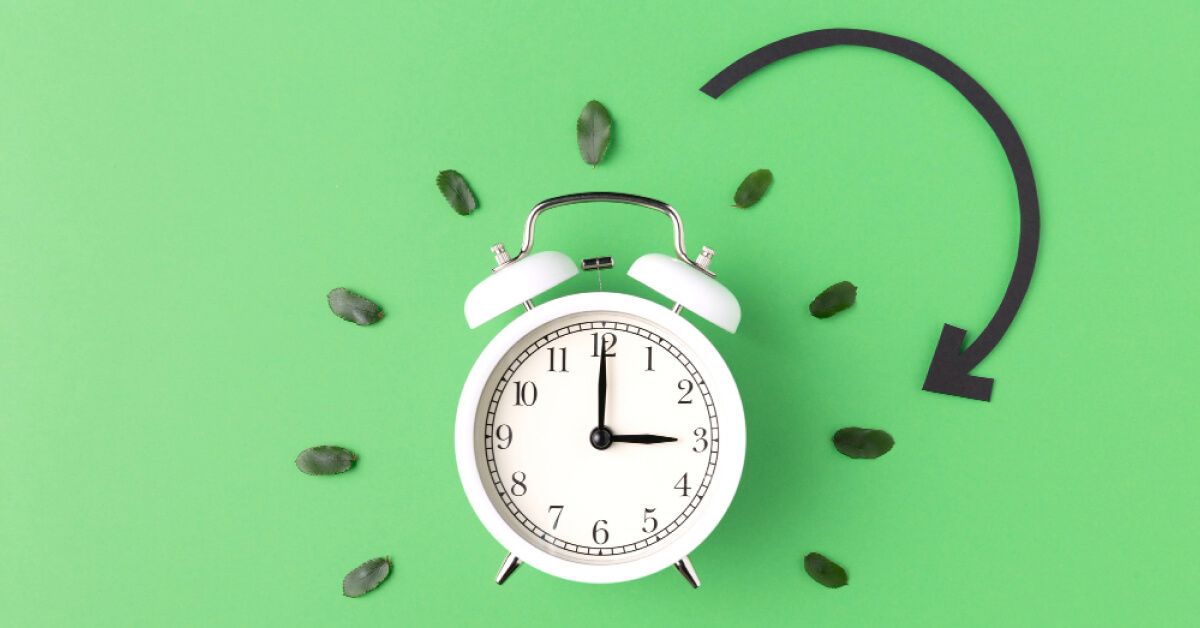 White alarm clock against a green background