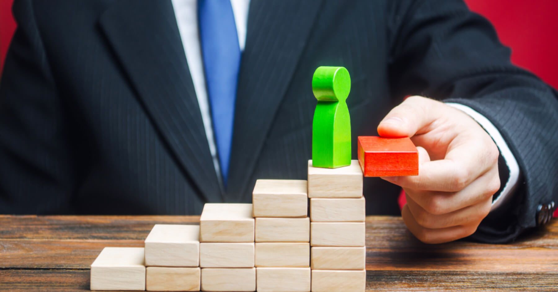 An employee using wooden blocks to symbolise an employee climbing
