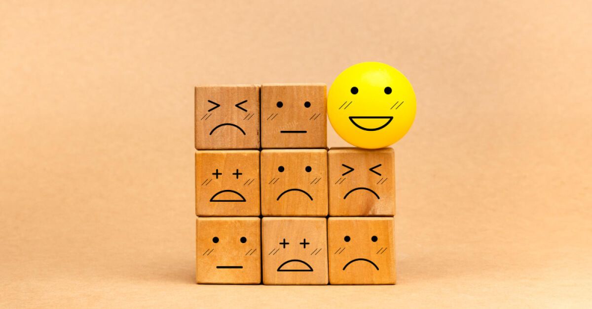 Various wooden blocks with emotion faces and a smiley face ball