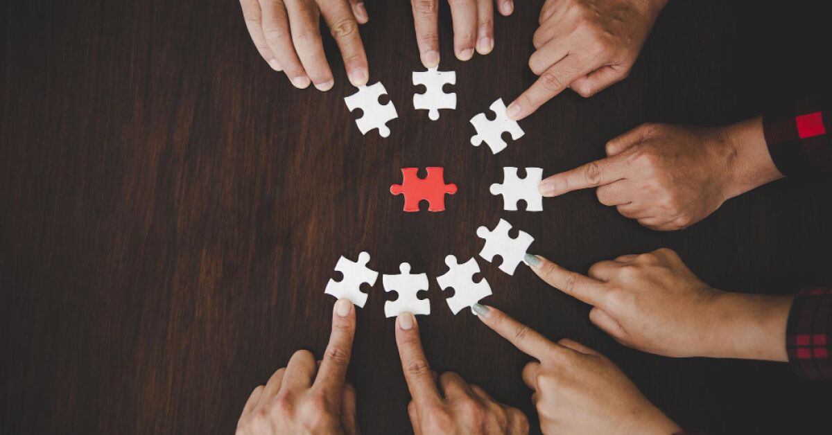 Employees forming puzzle circle