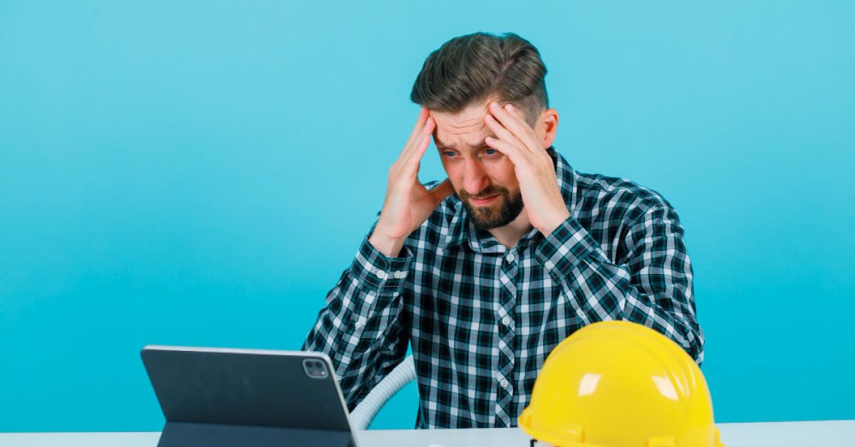 Blue collar worker stressed looking at tab