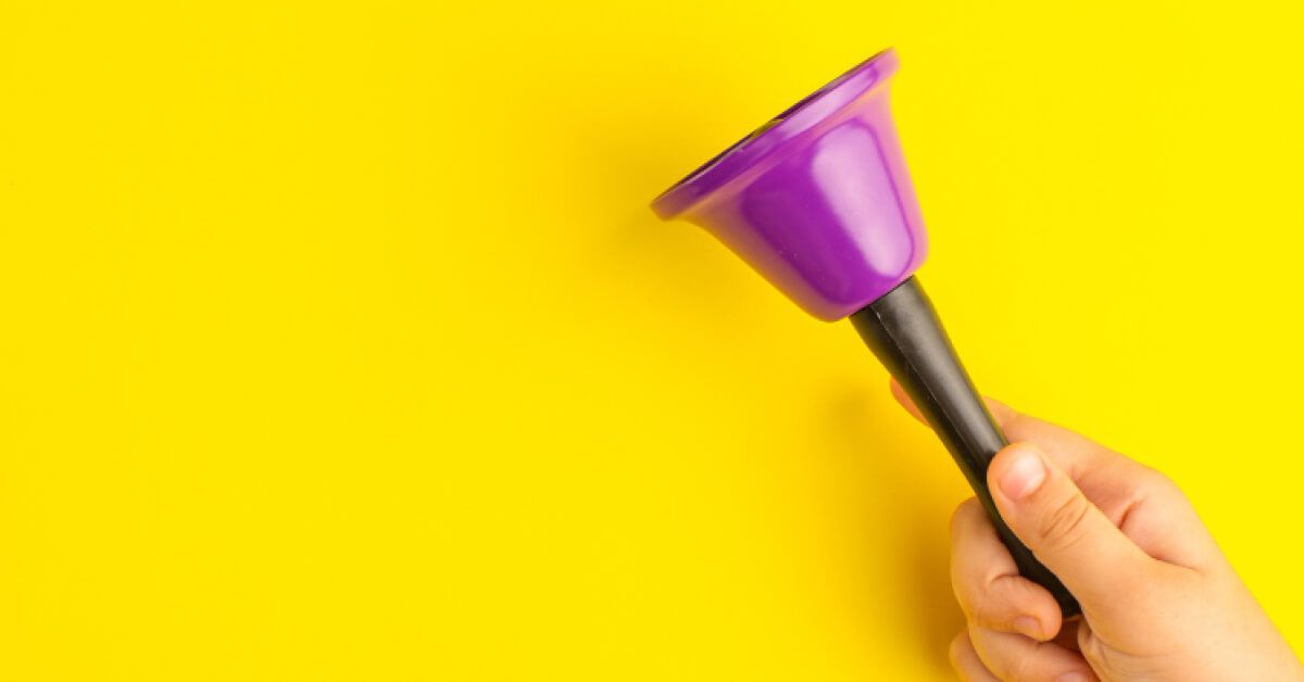 A purple bell against a yellow background
