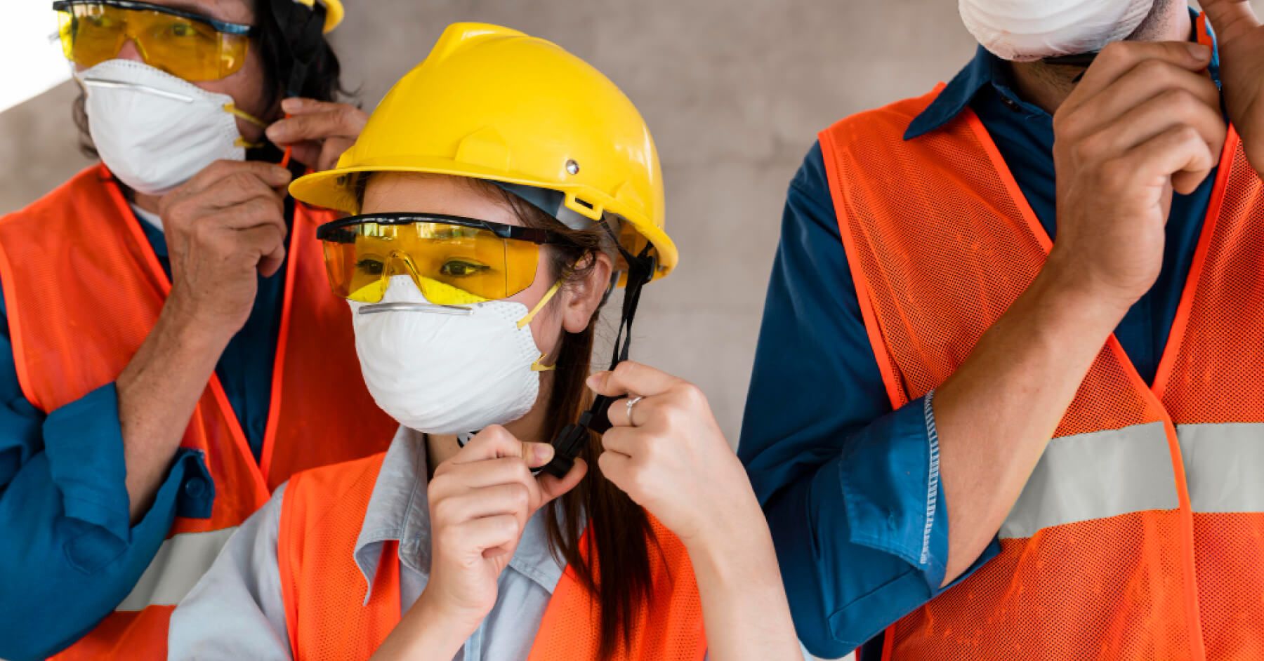 Blue collar workers buckling their helmets
