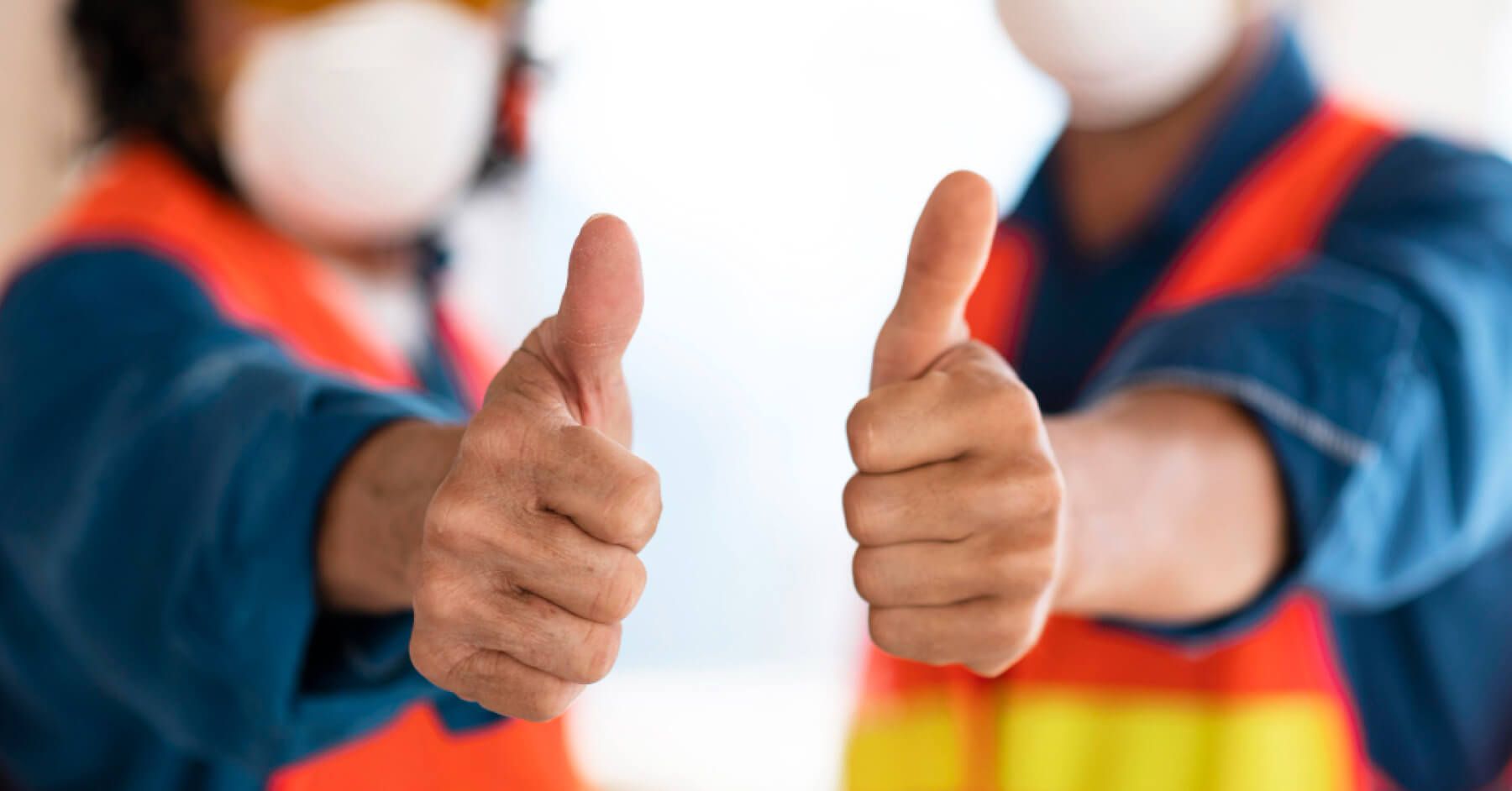 Two blue collar workers showing thumbs up