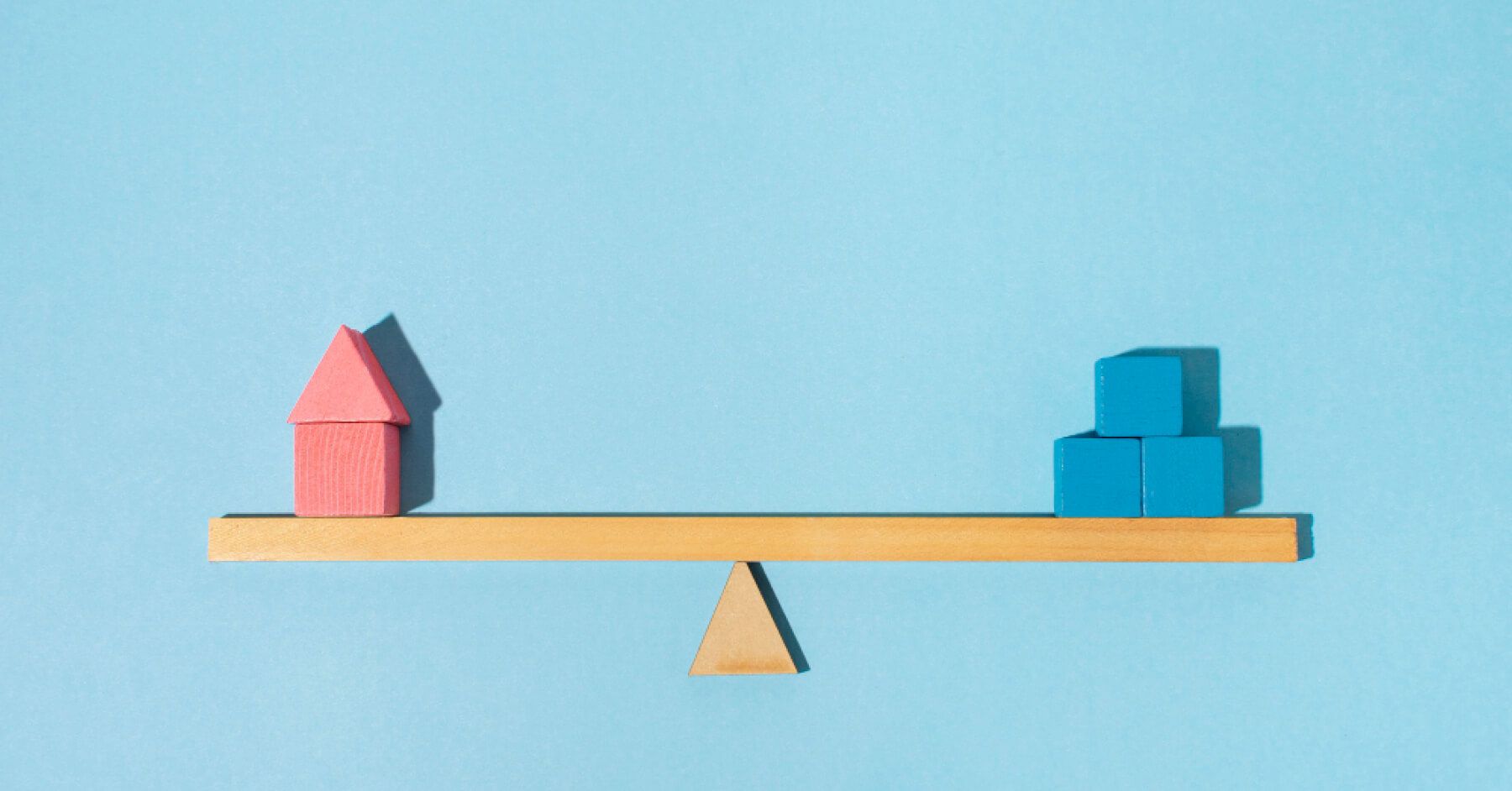 Red and blue blocks balanced on a wooden scale
