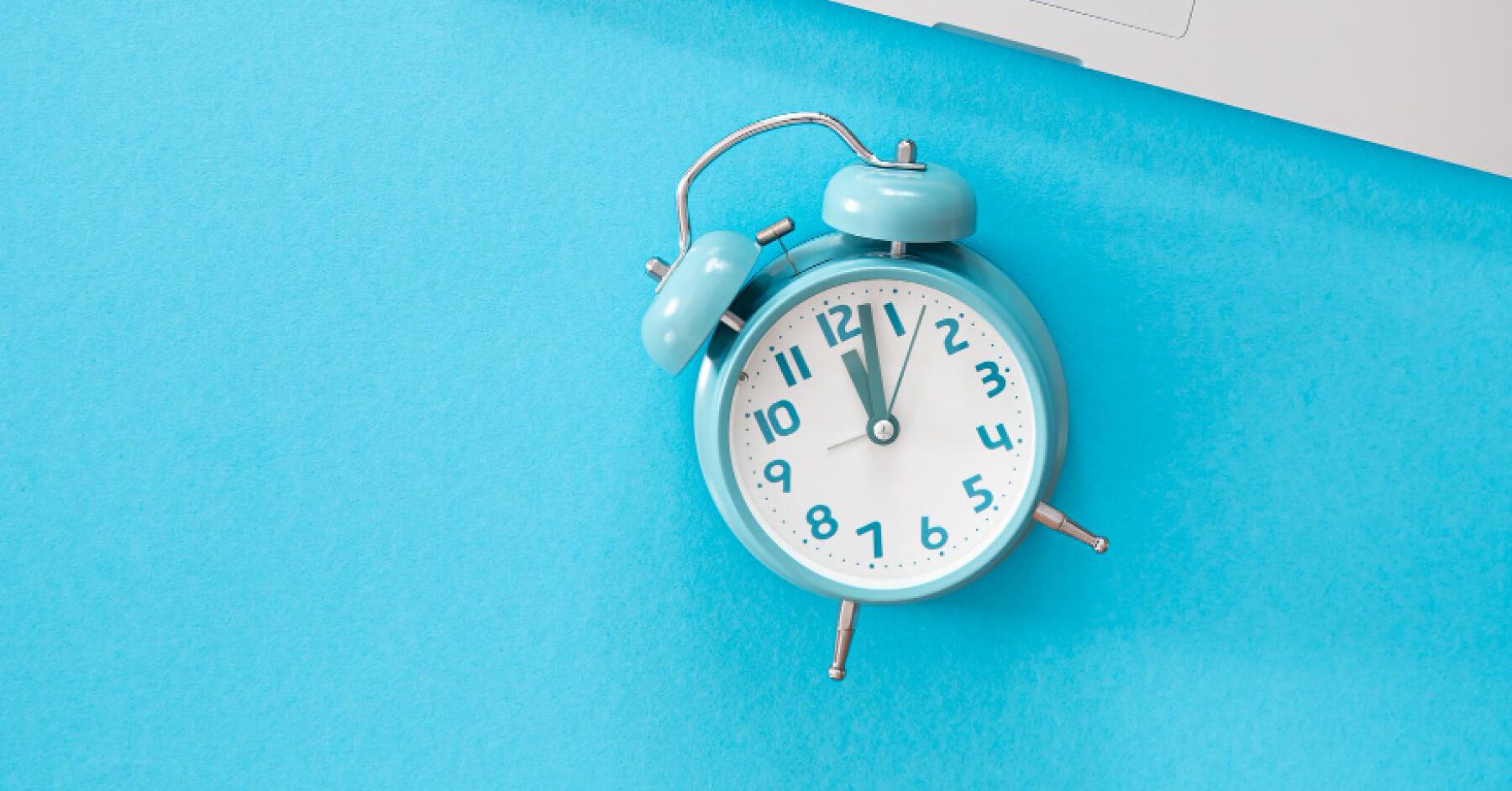 Blue alarm clock over a blue backdrop