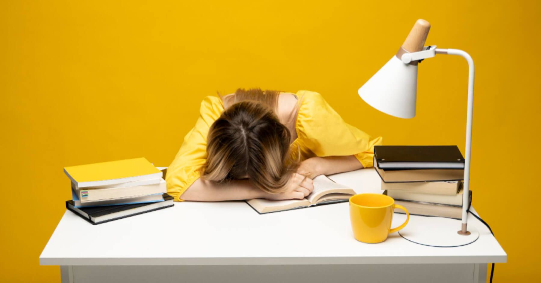 Stressed employee lying her head against her table